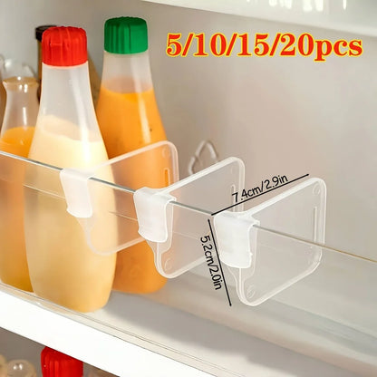 Clear adjustable divider separating bottles on a refrigerator shelf