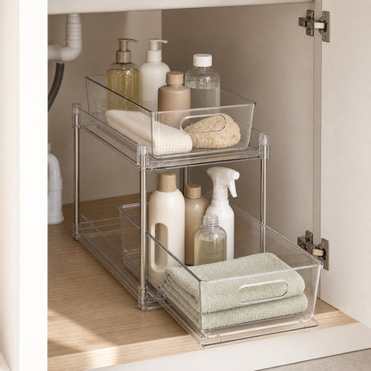 Clear two-tier pull-out organiser holding toiletries and folded towels on a bathroom benchtop