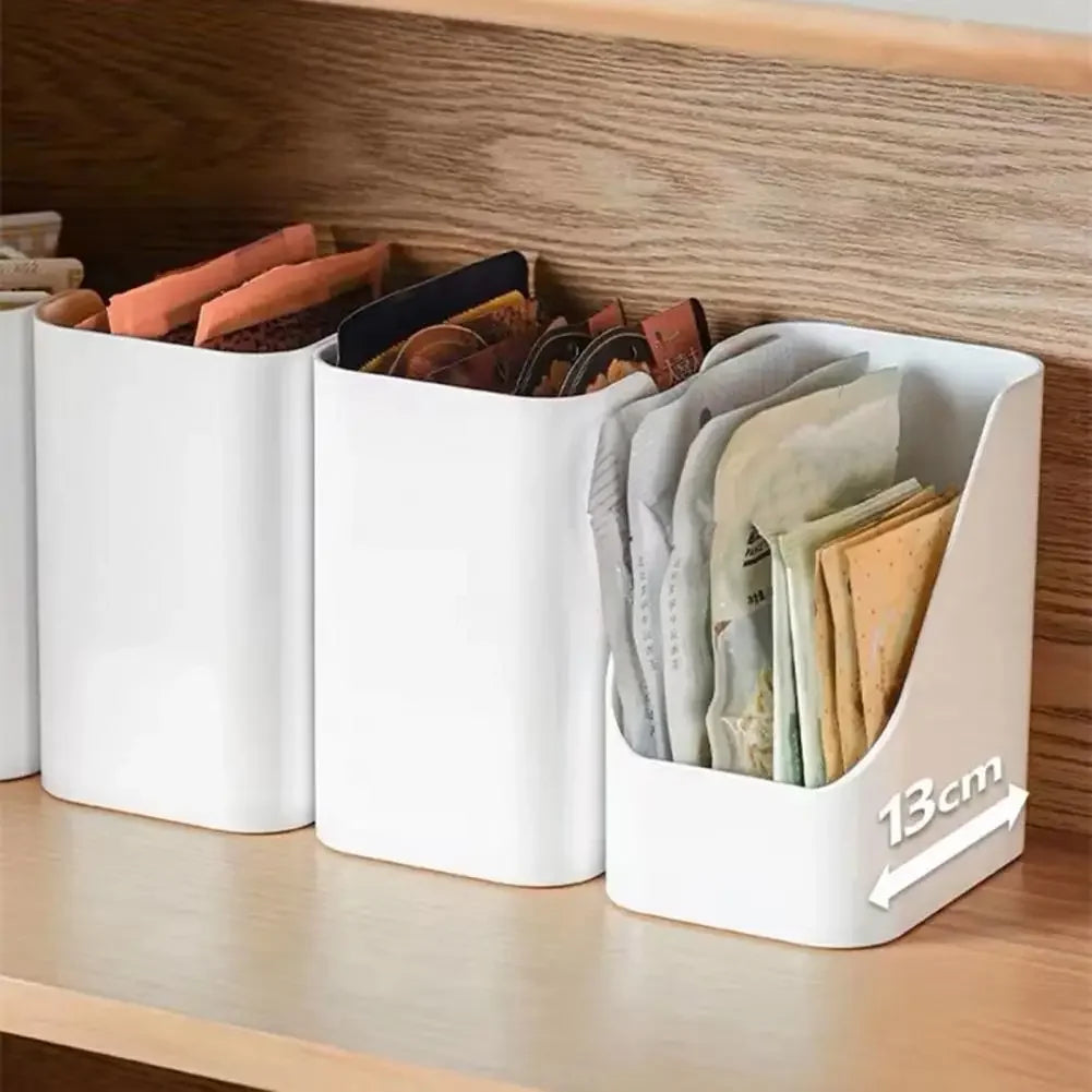 White compact organiser bins storing condiment and snack packets on a shelf