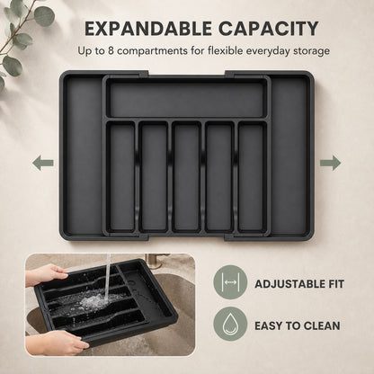 The cutlery tray shown expanded, with utensils filling the widened side compartments
